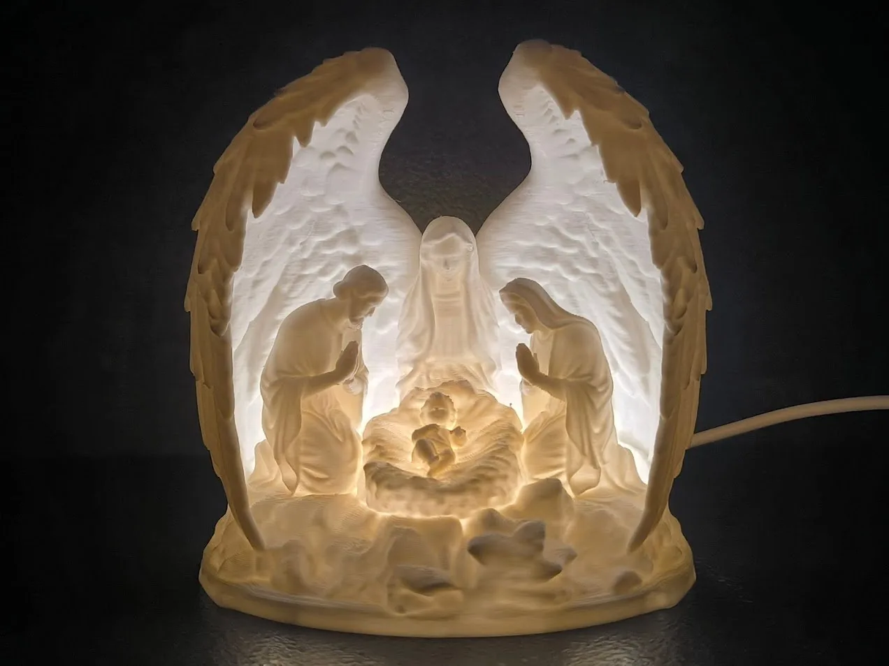 Pesebre iluminado con alas de ángel