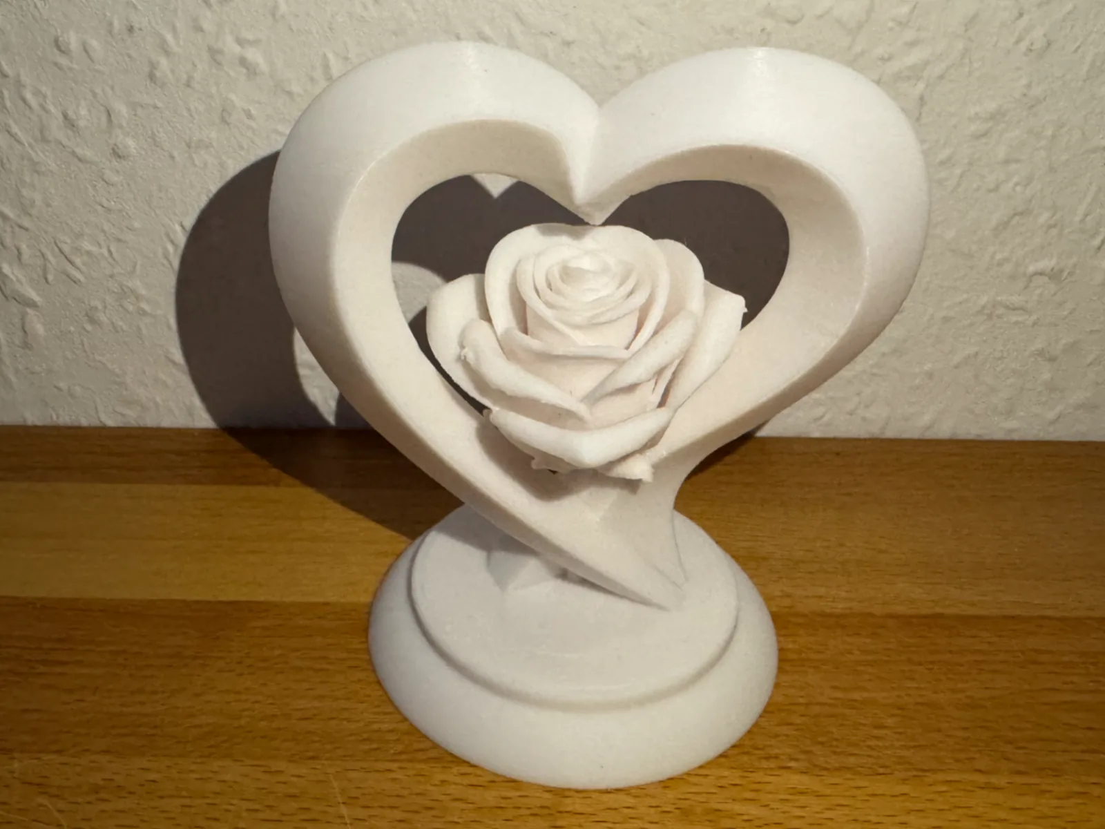 Corazón con rosa en pedestal